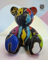Resin statue of a seated teddy bear. Decorative graphic design.
