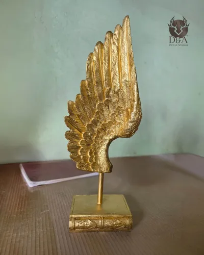 Goldene Engelsflügel-Skulptur – Dekorative Statue auf einem buchförmigen Sockel